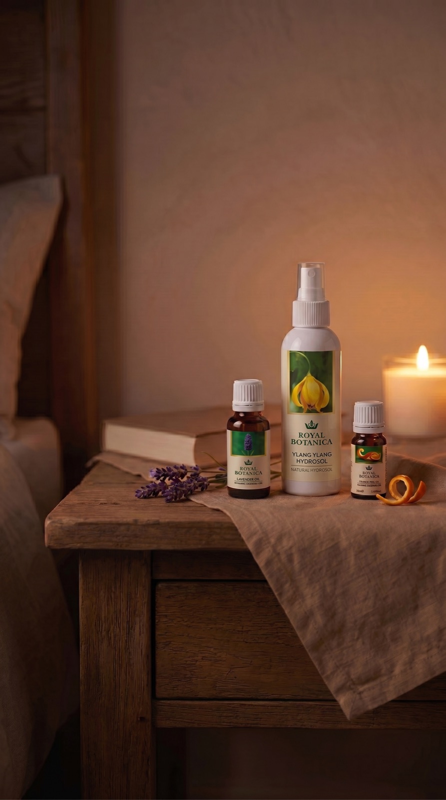 Royal Botanica Lavender Oil, Ylang Ylang Hydrosol and Orange Peel Oil on a bedside table by candlelight
